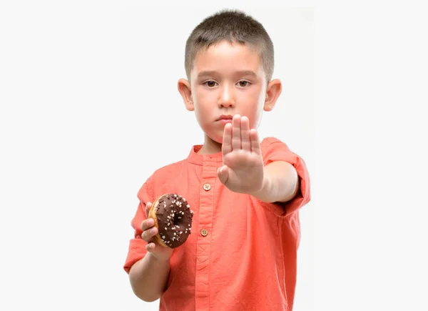 Criança Cabelos Escuros Comendo Donut Com Mão Aberta Fazendo Sinal — Fotografia de Stock