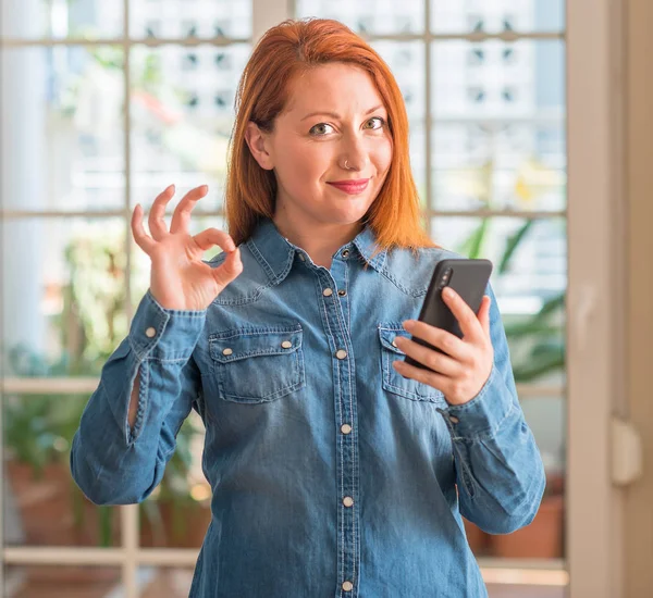 Rusovláska Žena Pomocí Smartphone Doma Dělá Cedulka Prsty Vynikající Symbol — Stock fotografie