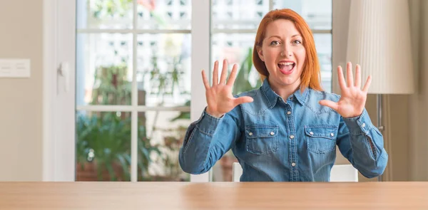 红头发的女人在家里显示和指向手指数十 而微笑的信心和快乐 — 图库照片