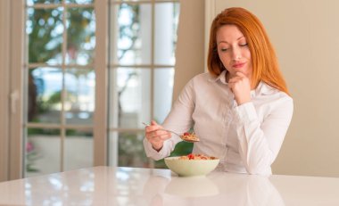 Kızıl saçlı kadın yeme tahıllar ile ahududu soru, çok karışık fikir hakkında ciddi bir yüz düşünme Anasayfa