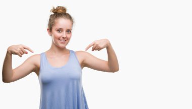 Yüzünde gülümseme ile kendinden emin görünüyorsun, kendini gururlu ve mutlu parmakları ile işaret sarışın genç kadın.