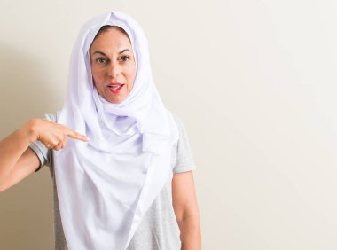 Sürpriz yüz işaret parmağı kendisine beyaz hijab giyen orta yaş Arap kadın