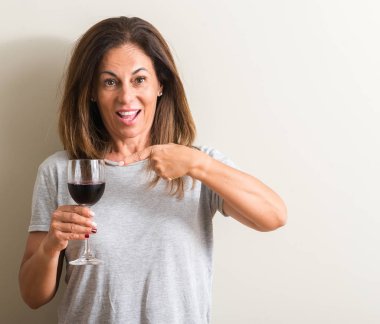 Orta yaş kadın el ve parmak ile işaret çok mutlu bir bardak kırmızı şarap içme