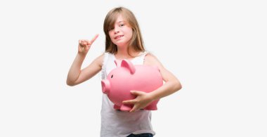 Genç Sarışın yürümeye başlayan çocuk kumbara tutan bir fikir ya da soru işaret parmağı gülen yüz, bir numara ile şaşırttı