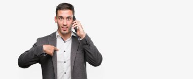 Yakışıklı genç adam kendisi için sürpriz yüz işaret parmağı ile Smartphone kullanarak