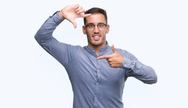 Giyen zarif yakışıklı genç gülümseyen yapım çerçeve elle ve parmakları ile mutlu yüz gözlük. Yaratıcılık ve Fotoğrafçılık kavramı.