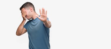 Yakışıklı genç casual adam kapsayan gözleri elleriniz ve üzgün dur jestle yapıyor ve korku ifadesi. Utandım ve negatif kavramı.