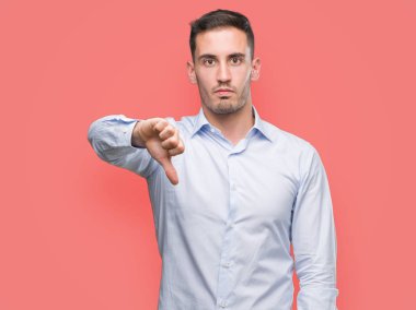 Mutsuz ve kızgın ret gösterilen ve başparmak aşağı hareketi ile negatif seyir yakışıklı genç iş adamı. Kötü ifade.