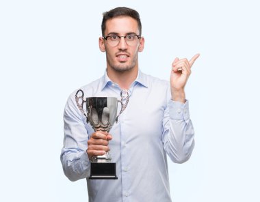 Kupa çok mutlu el ve parmak ile tarafına işaret tutan yakışıklı genç