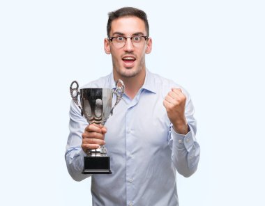 Duygu tezahürat gurur çığlık ve zafer ve başarı çok heyecanlı, kutluyor kupayı tutarak yakışıklı genç adam