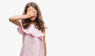 Esmer İspanyol kız pembe elbisesi gülümseyen ve gözler için sürpriz kapsayan yüz el ile gülüyor. Kör kavramı.