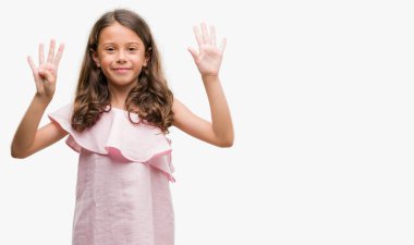 Esmer Latin kız pembe elbise gösterme ve parmakları ile işaret giyiyor numara 9 kendinden emin ve mutlu gülümseyerek süre.