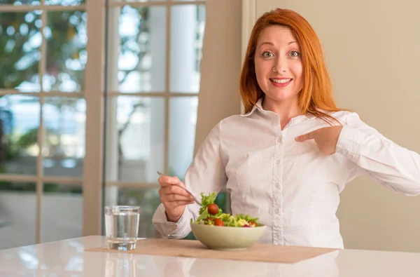 Roodharige Vrouw Eten Frisse Groene Salade Thuis Met Verrassing Gezicht — Stockfoto