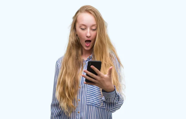 Mulher Adolescente Loira Usando Smartphone Assustado Choque Com Rosto Surpresa — Fotografia de Stock