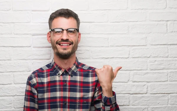 Jonge Volwassen Man Die Witte Bakstenen Muur Aan Wijzen Tonen — Stockfoto