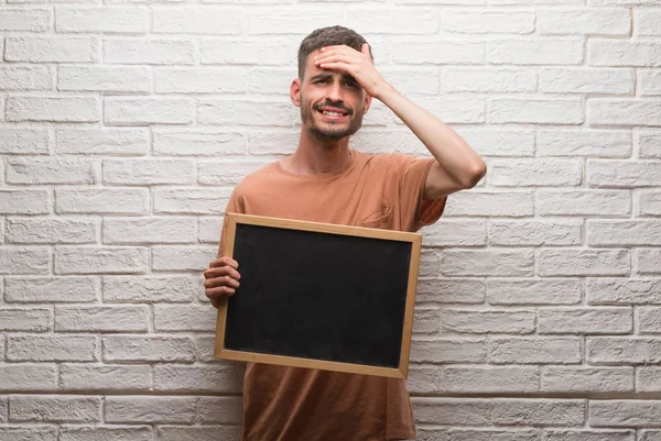 Hombre Joven Adulto Sobre Pared Ladrillo Sosteniendo Pizarra Estresado Con — Foto de Stock