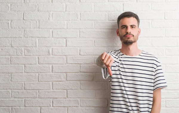 Junger Erwachsener Mann Steht Mit Wütendem Gesicht Über Weißer Backsteinmauer — Stockfoto