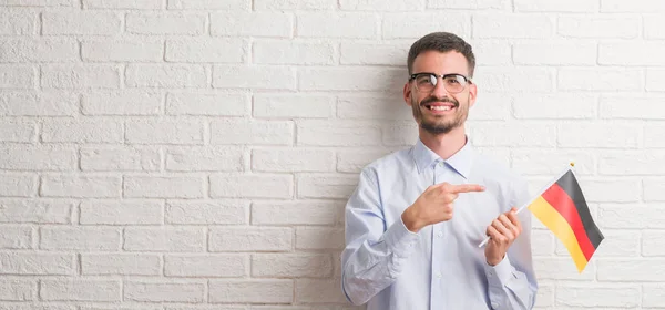 Ung Vuxen Man Över Tegelvägg Holding Flagga Tyskland Mycket Glad — Stockfoto