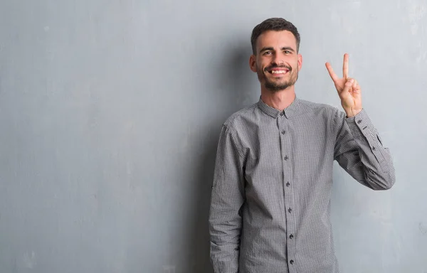 Joven Hombre Adulto Pie Sobre Pared Grunge Gris Mostrando Apuntando — Foto de Stock