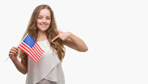 Mujer Rubia Joven Sosteniendo Bandera Con Cara Sorpresa Señalando Dedo —  Fotos de Stock