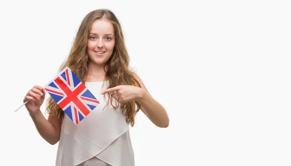 Młoda Blondynka Kobieta Trzyma Flagę Wielkiej Brytanii Bardzo Szczęśliwy Wskazując — Zdjęcie stockowe