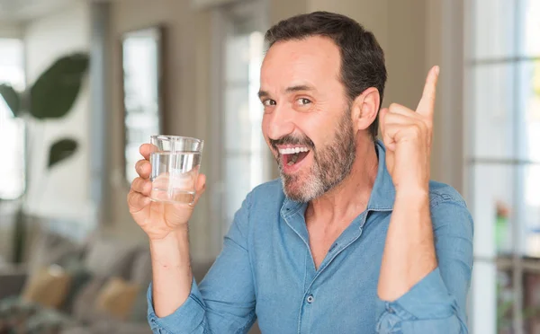 中間のアイデアに驚いて水のガラスを飲む人の年齢や幸せそうな顔 ナンバーワンと人差し指の質問 — ストック写真