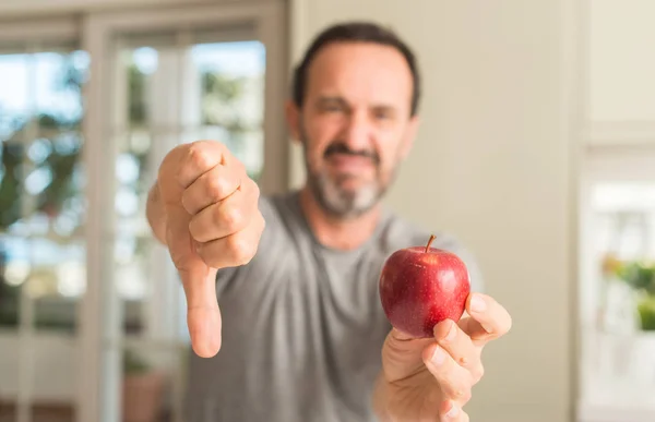 怒った顔 ダウン親指で嫌悪感を示すマイナス記号 拒絶反応の概念と中年の男性が食べて健康的な赤いリンゴ — ストック写真