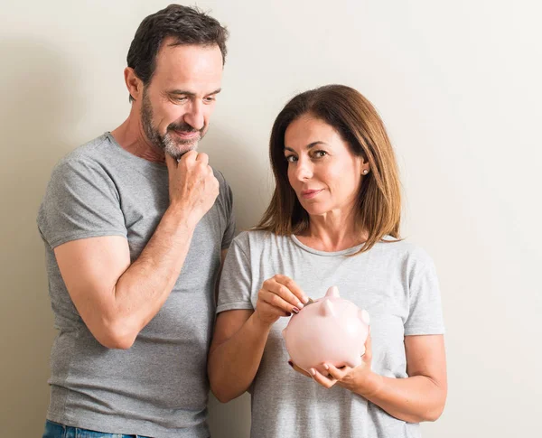 Casal Meia Idade Mulher Homem Segurando Porquinho Cara Séria Pensando — Fotografia de Stock