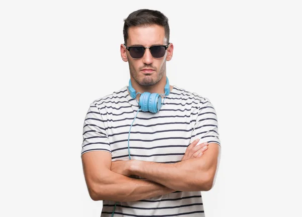 Όμορφος Νεαρός Άνδρας Φορώντας Ακουστικά Σκεπτικιστής Και Νευρικό Αποδοκιμασίας Έκφραση — Φωτογραφία Αρχείου