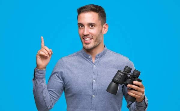 Handsome Young Man Looking Binoculars Surprised Idea Question Pointing Finger — Stock Photo, Image