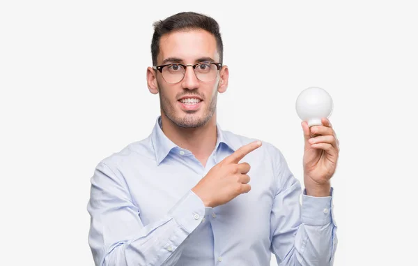 ハンサムな若い男の手と指で指している非常に幸せのアイデアとして電球を保持しています — ストック写真