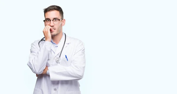 不安や両手の爪を噛んで口の中で緊張を探してハンサムな若い医者の男 不安の問題 — ストック写真