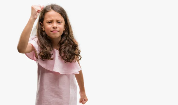 ブルネット ヒスパニック系の女の子は 怒りと不満と怒りで叫びながら激怒の拳を上げる狂牛病のピンクのドレスを着ています 怒りと攻撃的な概念 — ストック写真