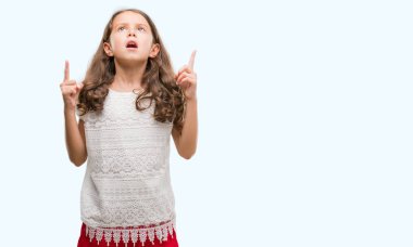 Esmer Latin kız hayran ve yukarıya bakıp parmakları ile işaret şaşırttı ve silah kaldırdı.