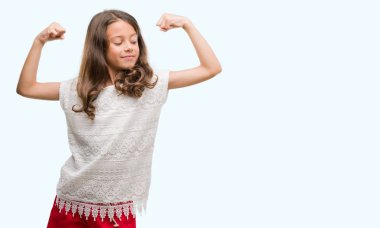 Esmer Latin kız gururlu gülümseyen kol kasları gösterilen. Fitness kavramı.