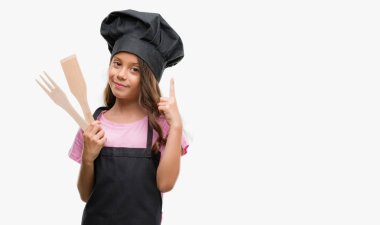 Esmer Latin kız giyen üniforma bir fikirle sürpriz yemek veya gülen yüz, bir numara ile işaret parmağı soru