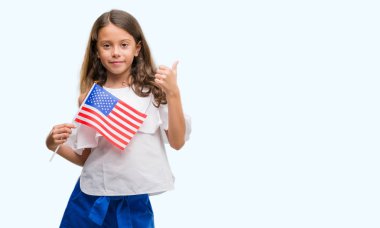 Ok işareti, başparmak ile parmak, mükemmel işareti yapıyor kocaman bir gülümseme ile Amerika Birleşik Devletleri bayrağı mutlu tutarak esmer Latin kız