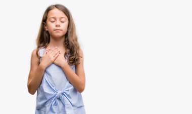 Esmer Latin kız göğüs kapalı gözlerle ellerinde ve yüzünde minnettar jest ile gülümseyen. Sağlık kavramı.