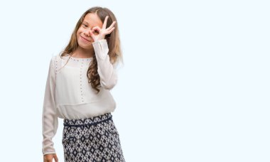 Esmer Latin kız gülümsüyor, parmakları ile mutlu yüz üzerinden seyir göz el ile ok jest yapıyor.