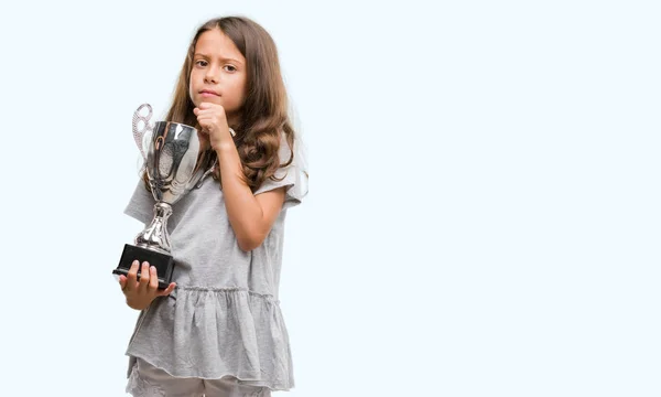 Brunette Hispanic Girl Holding Trophy Serious Face Thinking Question Very — Stock Photo, Image