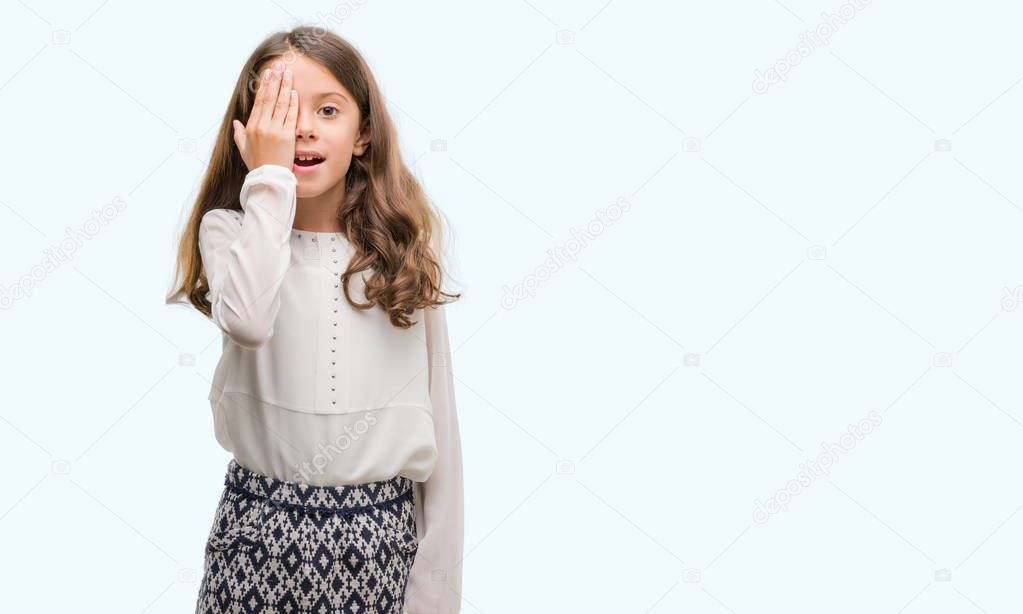 Brunette hispanic girl covering one eye with hand with confident smile on face and surprise emotion.