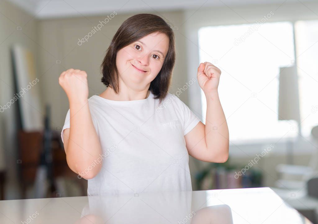 Down syndrome woman at home screaming proud and celebrating victory and success very excited, cheering emotion