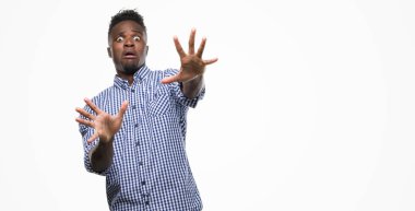 Şokta bağırarak korkuyor ve dehşet korku ifade dur hareketi el ile ile mavi gömlek giymiş genç Afro-Amerikan adam. Panik kavramı.