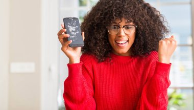 Duygu tezahürat gurur çığlık ve zafer ve başarı çok heyecanlı, kutluyor kırık smartphone tutan Afrikalı-Amerikalı kadın