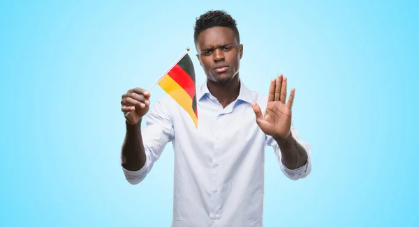 Joven Hombre Afroamericano Sosteniendo Bandera Alemana Con Mano Abierta Haciendo —  Fotos de Stock