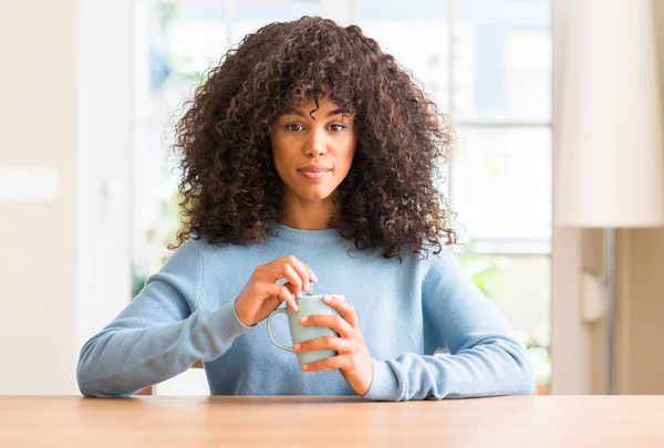 Mujer Afroamericana Sosteniendo Una Taza Café Casa Con Una Expresión —  Fotos de Stock