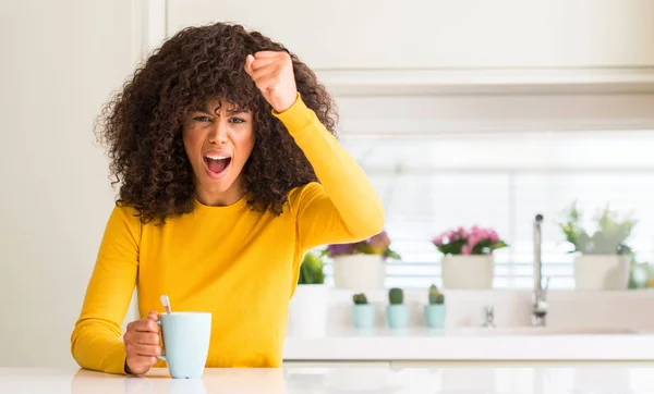 美丽的非洲裔美国妇女拿着一杯咖啡在家里恼怒和沮丧的呼喊与愤怒 疯狂和叫喊与举手 愤怒的概念 — 图库照片