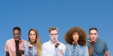 Grup üzerinde bir öpücük el ile güzel ve seksi olmak hava üfleme kamera bakarak mavi blackground arkadaşıyla bileşimi. Aşk ifade.