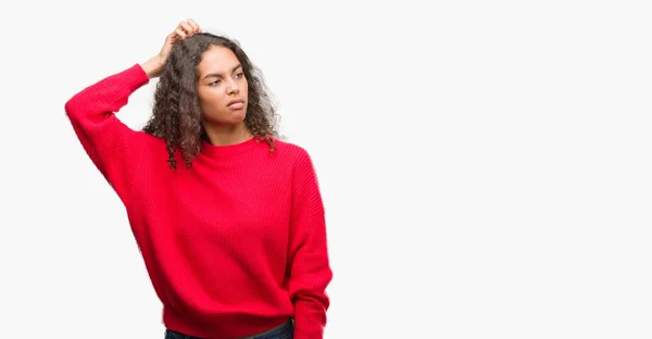 穿着红色毛衣的年轻西班牙女人迷惑和怀疑问题 疑惑不定 用手在头上思考 沉思概念 — 图库照片