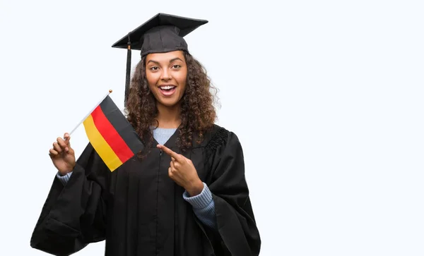 Jovem Hispânica Vestindo Uniforme Formatura Segurando Bandeira Alemanha Muito Feliz — Fotografia de Stock